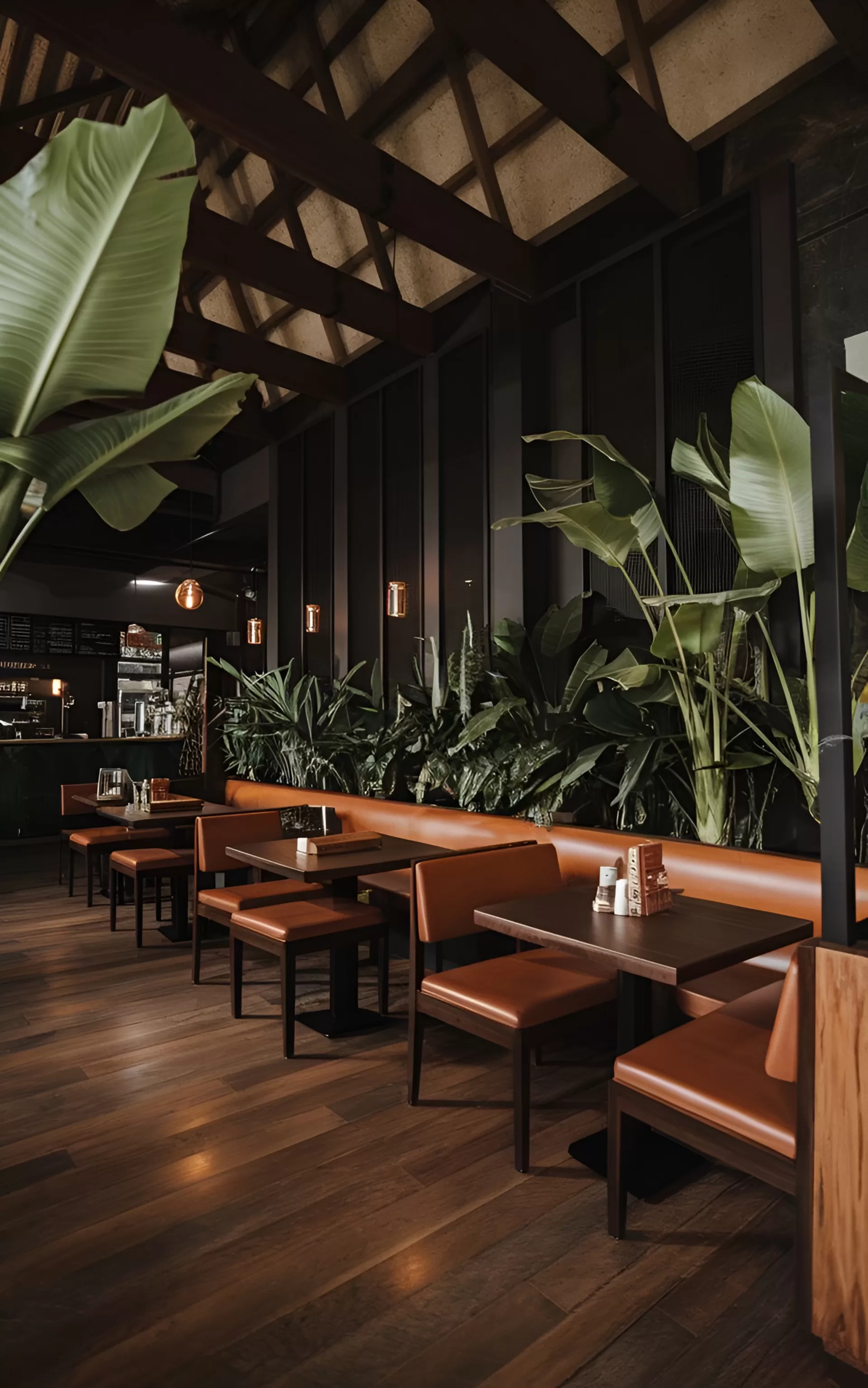 Clave dining room with leather banquettes, dark wood tables and tropical plants